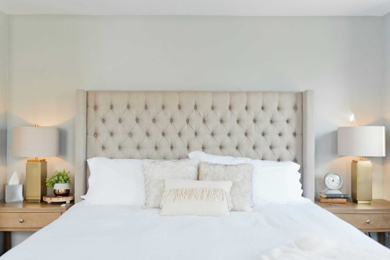 A clean bedroom with a bed that has been made and pillows neatly placed on the bed.