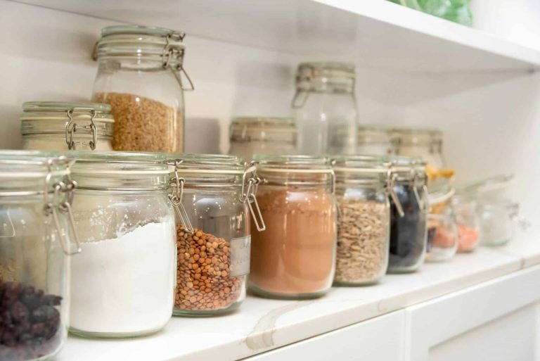 A well-organized pantry with glass containers that hold staple pantry items.