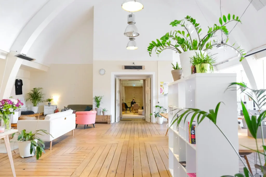 Bright commercial office space with hardwood floors, arched ceilings, lush plants, and open seating areas — commercial cleaning services in Lincoln NE.